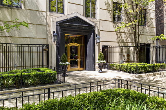 Front view of a building entrance with a decorative black and gold doorway.