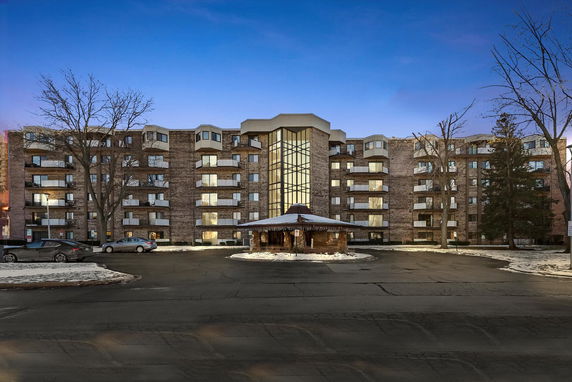 Front view of a multi-story residential building with a central glass section.