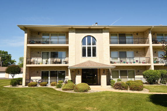 Front view of a three-story apartment building with balconies.