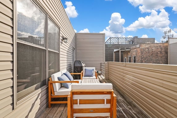 Rooftop area with outdoor seating and a partial view of nearby buildings.