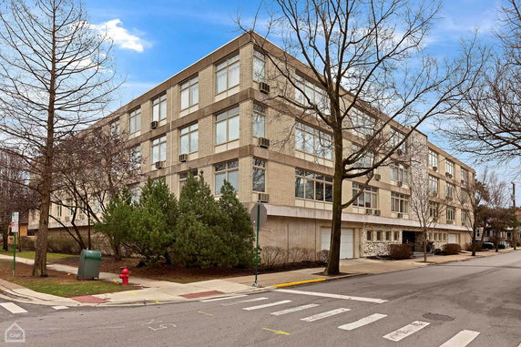 Front view of a multi-story building with brick exterior and large windows.