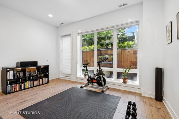 Indoor exercise area with a stationary bike and window view.