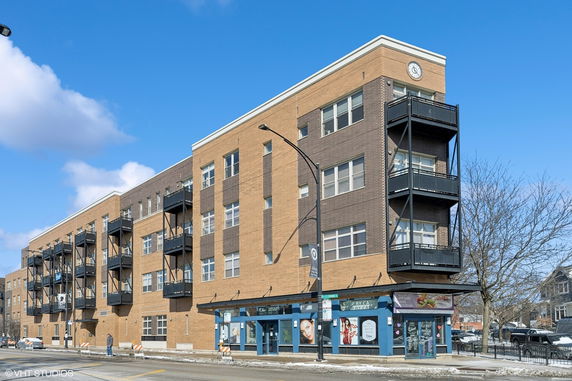 Front view of a multi-story brick building with balconies.