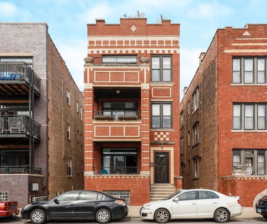 Front view of a multi-story brick apartment building.