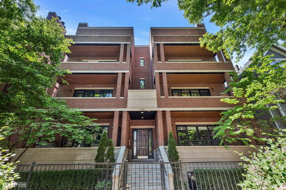 Front view of a multi-story brick building with balconies.