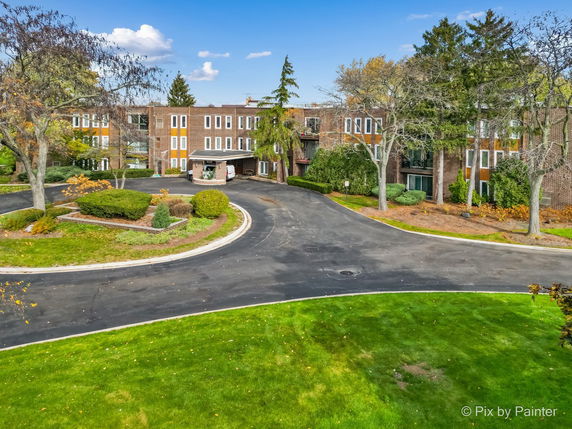 Front view of a multi-story building with a large circular driveway.