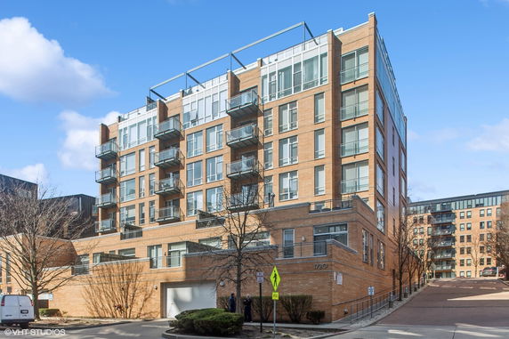 Front view of a multi-story brick apartment building with balconies.