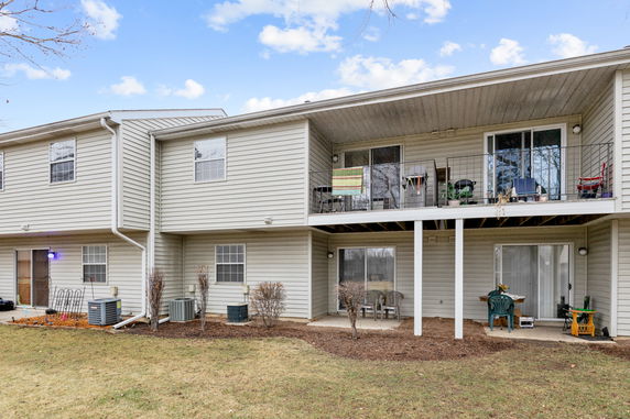 Back view of a two-story residential building with balconies and patios.