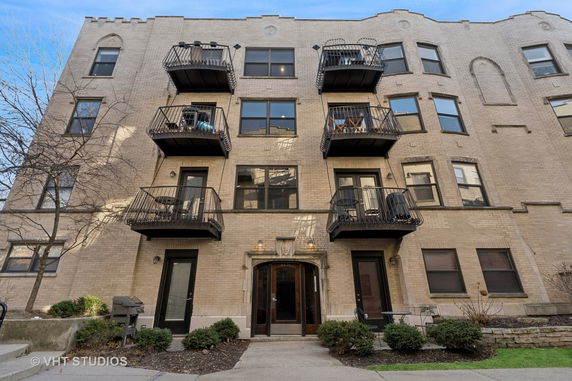 Front view of a multi-story apartment building with balconies.