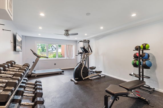 Indoor gym area with exercise equipment and weights.