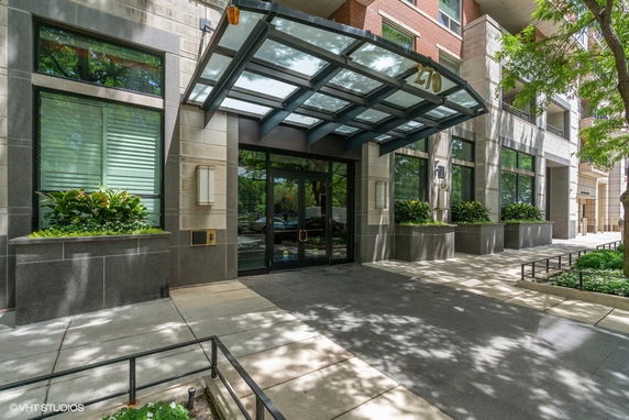 Front view of a multi-story building with a glass canopy over the entrance.