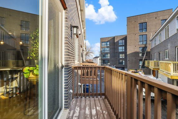 View from a balcony overlooking a courtyard with multiple buildings in the background.