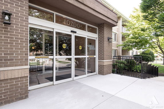 Front view of a building entrance with glass doors and brick exterior.