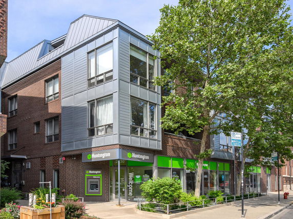 Front view of a modern multi-story building with brick and metal facade.