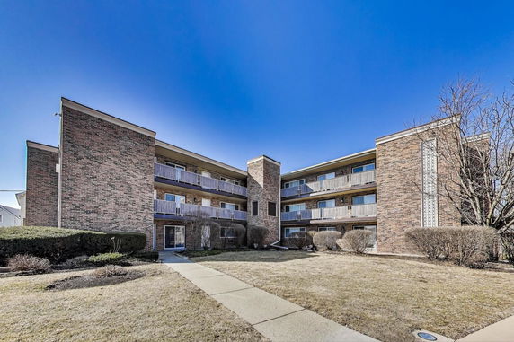 Front view of a multi-story apartment building with balconies.