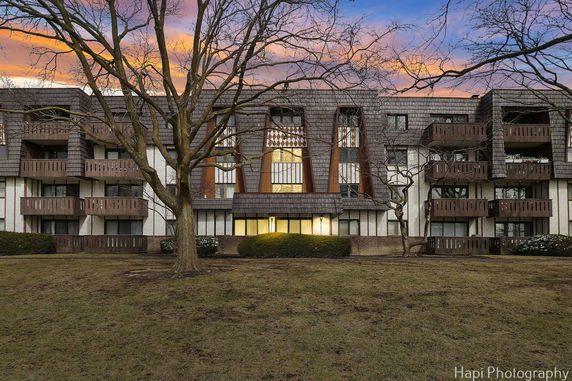 Front view of a multi-story building with balconies and distinct architectural features.