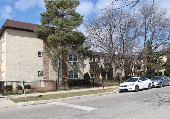 Front view of a multi-story apartment building with balconies.