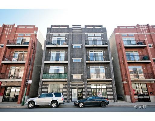 Front view of a multi-story apartment building with balconies and large windows.