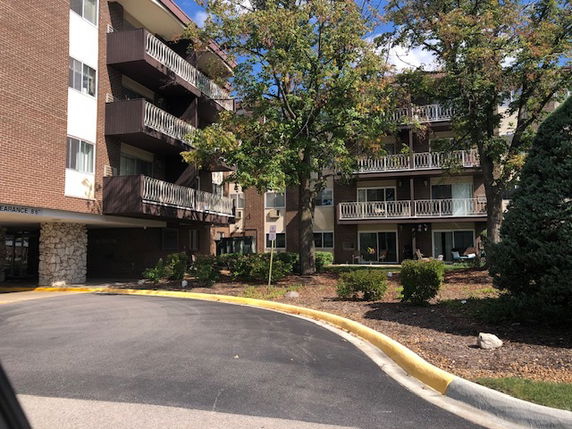 Front view of a multi-story apartment building with balconies.