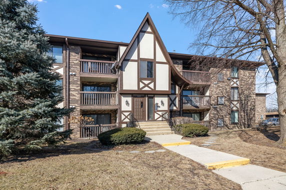 Front view of a multi-story residential building with Tudor-style architecture.