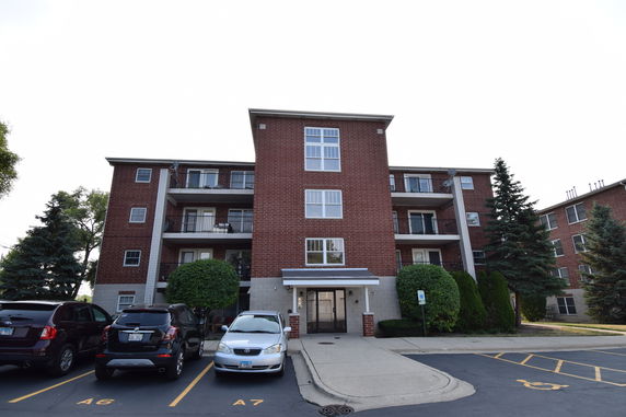 Front view of a multi-story apartment building with brick facade.