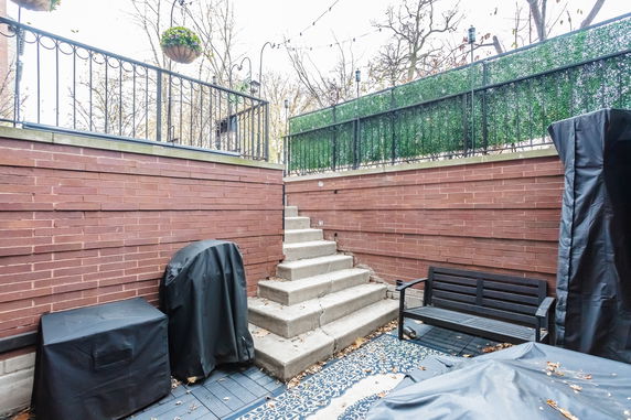 Outdoor terrace area with brick walls, steps, and seating.