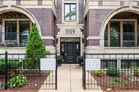 Front view of a building with brick facade and entry gate.