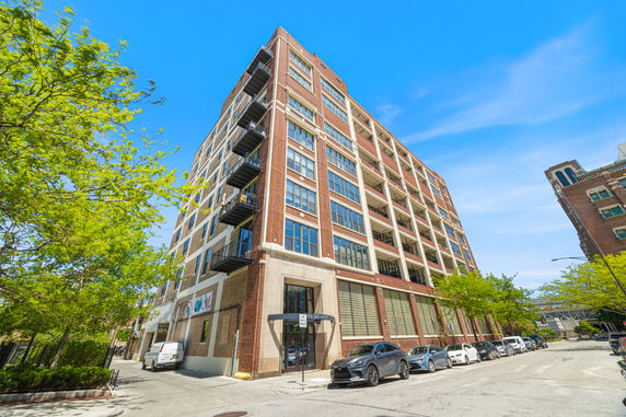 Front view of a multi-story brick building with large windows.