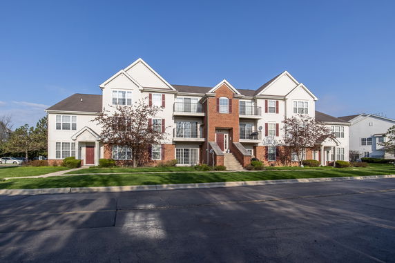 Front view of a multi-story residential building with brick and siding exterior.
