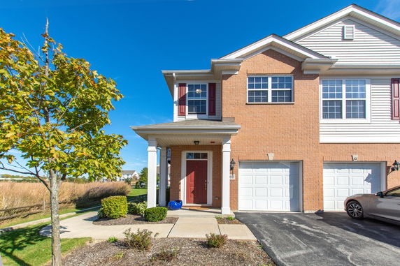 Front view of a two-story house with a red door and double garage.