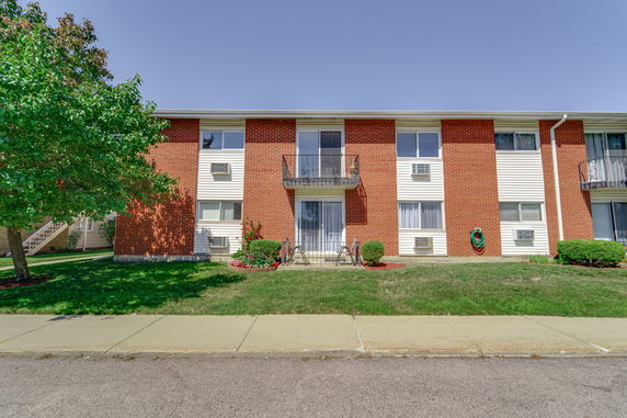 Front view of a two-story apartment building with brick and siding exterior.