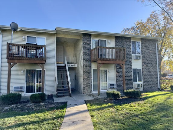 Front view of a two-story apartment building with balconies.
