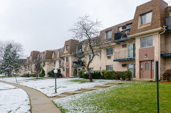 Front view of a multi-story apartment building with multiple balconies.