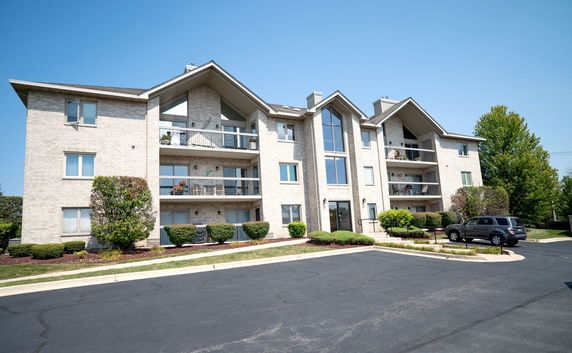 Front view of a mid-rise apartment building with balconies.