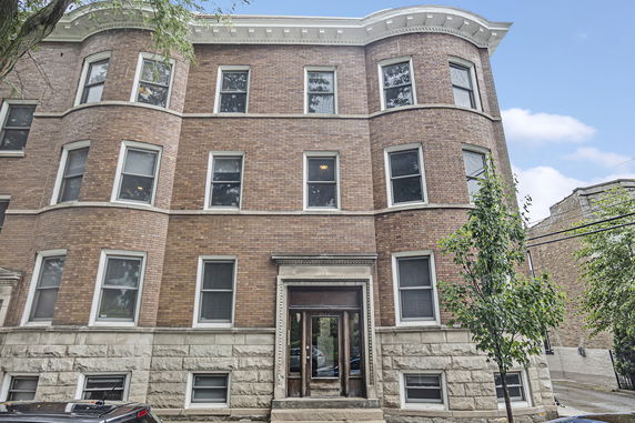 Front view of a multi-story brick building with multiple windows.