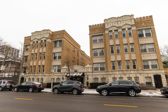 Front view of a four-story apartment building with decorative elements.