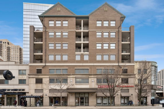 Front view of a multi-story brick building with commercial space on the ground level.