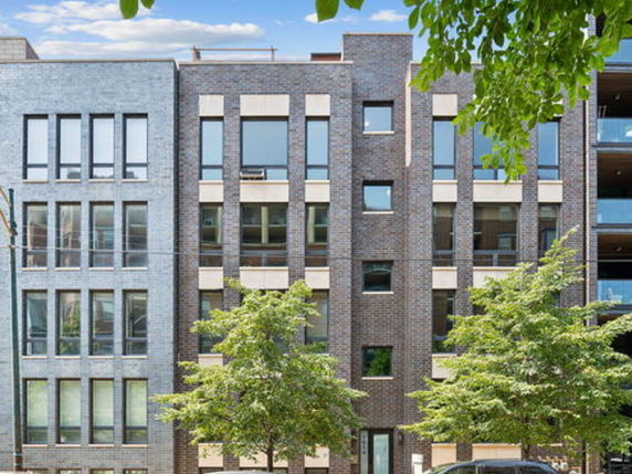 Front view of a multi-story building with a modern brick facade.