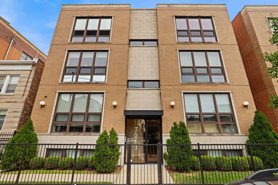 Front view of a multi-story building with large windows and a central entrance.