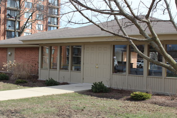 Front view of a single-story building with large windows and double doors.