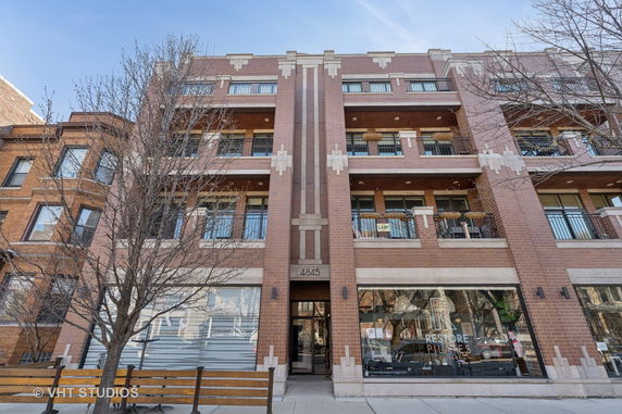 Front view of a multi-story brick building with balconies.