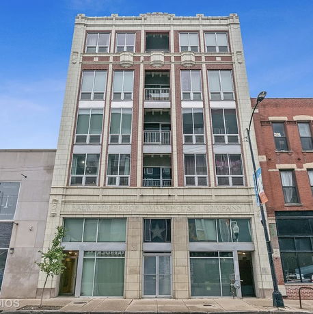 Front view of a multi-story building with large windows.