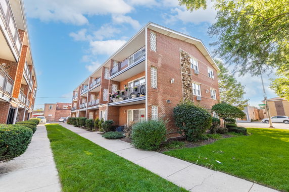 Corner view of a three-story apartment building with balconies.