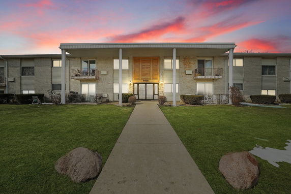 Front view of a two-story building with a central entrance and balconies.