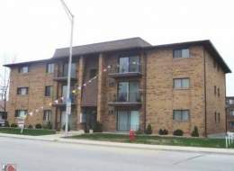 Front view of a three-story brick apartment building.