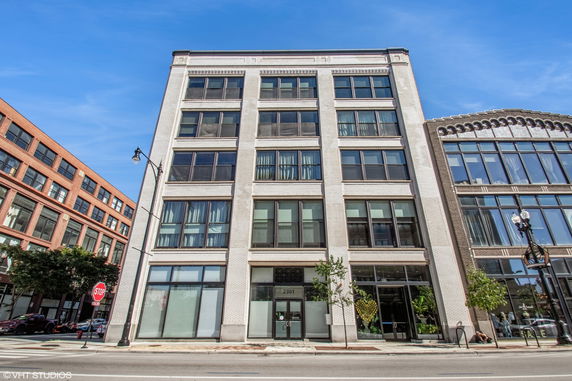 Front view of a multi-story building with large windows.