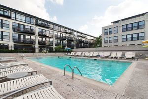 Outdoor swimming pool area with surrounding buildings.