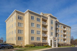 Front view of a multi-story apartment building with balconies.