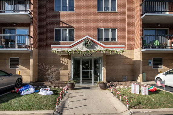 Front view of an apartment building with brick exterior and balconies.