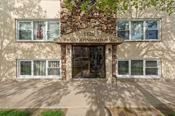 Front view of a condominium building with stone and brick facade.
